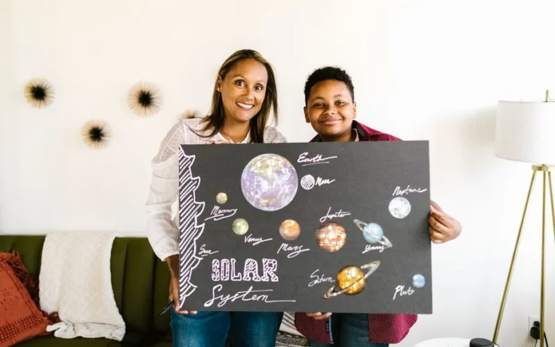 A mother and son proudly display their handmade solar system project.