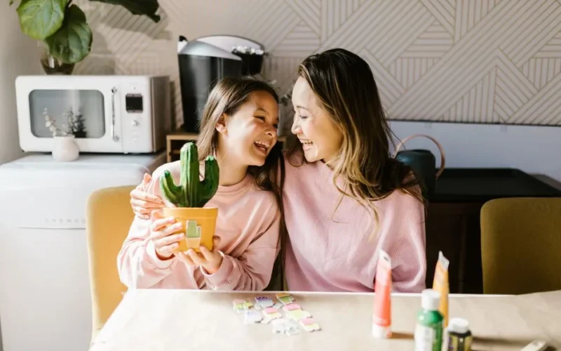 A joyful moment at home as a mother and daughter engage in arts and crafts together.