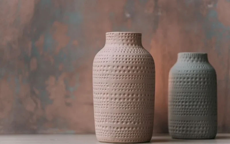 Two handcrafted ceramic vases with textured patterns set against a subtle backdrop.