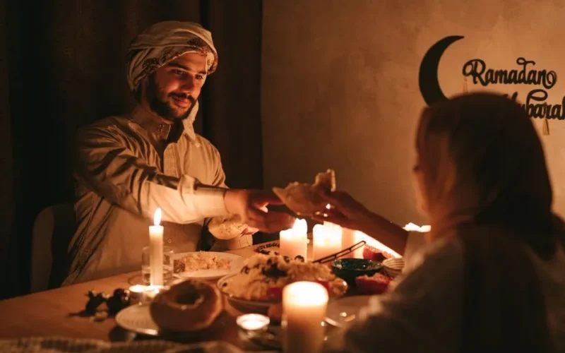 A warm, candlelit dinner during Ramadan with a Muslim family sharing a meal.