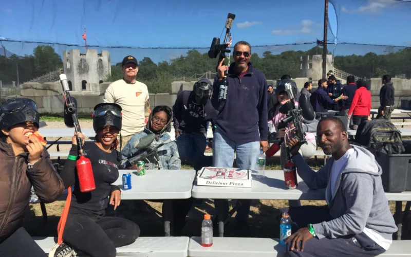 Partial group photo from a Nightly Show outing for Mike Yard's (bottom right) paintball birthday party with director Andre Allen (center), crew member Jonathan Ginter (standing left), and some of Mike Yard's friends and family