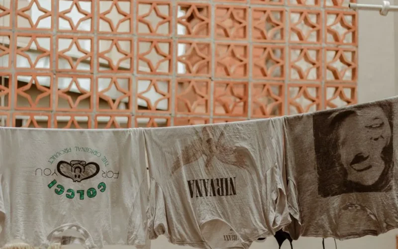 Retro t-shirts, including a Nirvana print, drying outdoors on a clothesline.