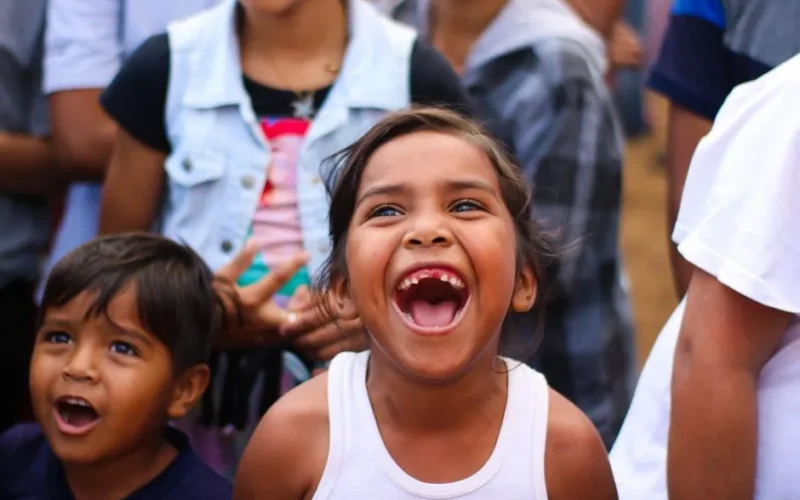A group of children laughing joyfully at an outdoor event, capturing a moment of pure happiness.