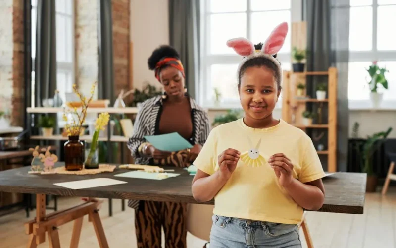 Mother and daughter enjoying Easter crafts at home, featuring bunny ears and colorful creativity.