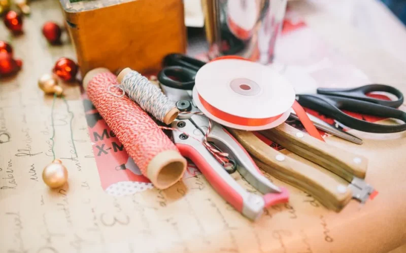 A close-up of various crafting supplies and tools on a table for festive DIY projects.