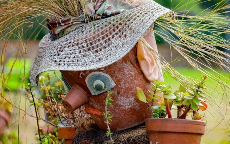 Colorful garden decoration featuring whimsical pot sculpture with plants.