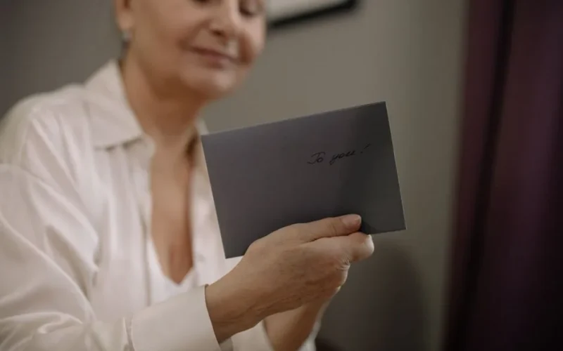 An elderly woman holds a heartfelt letter. The envelope reads 'To you' in elegant handwriting.
