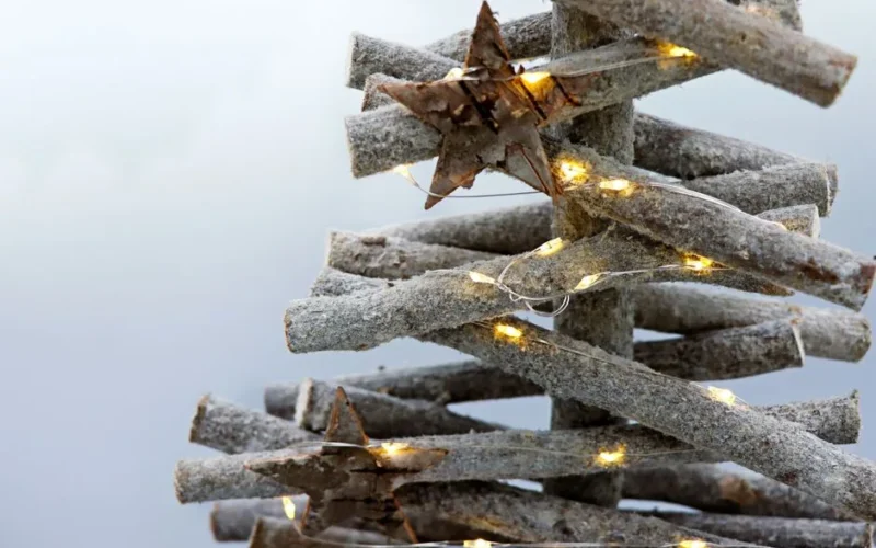 A minimalistic eco-friendly wooden Christmas tree decorated with stars and lights.