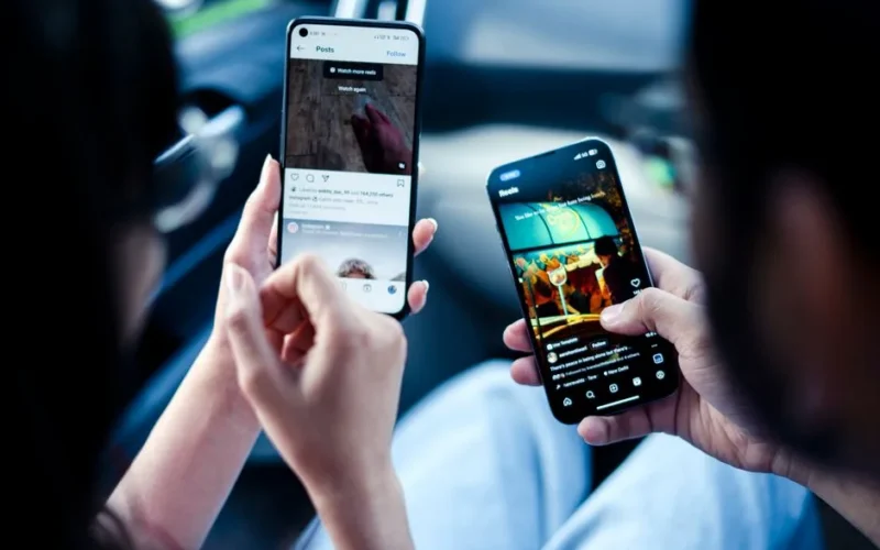 A couple engaging with social media on smartphones indoors, illustrating modern digital connectivity.