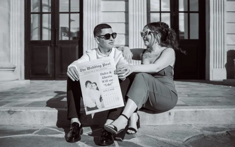Couple sitting with engagement announcement in a newspaper-style theme.