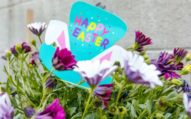 Colorful Easter greeting card surrounded by blooming flowers. Perfect for spring celebrations.
