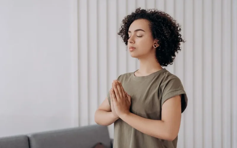 Young woman meditating indoors, practicing mindfulness and relaxation. Peaceful and serene atmosphere.