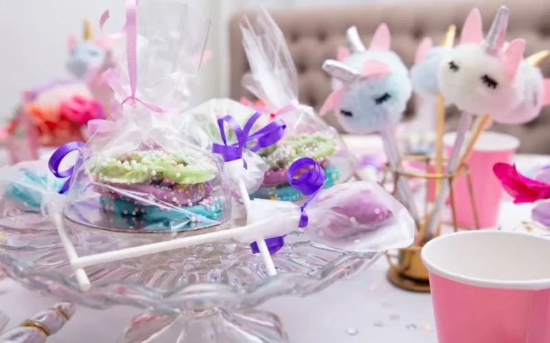Unicorn-themed birthday party table with colorful treats and decorations.