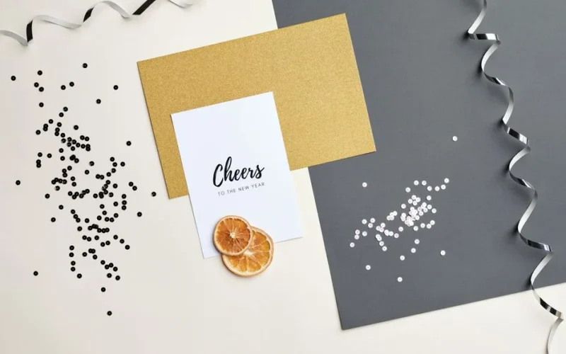 Flat lay of New Year's card with confetti and ribbon for a festive celebration
