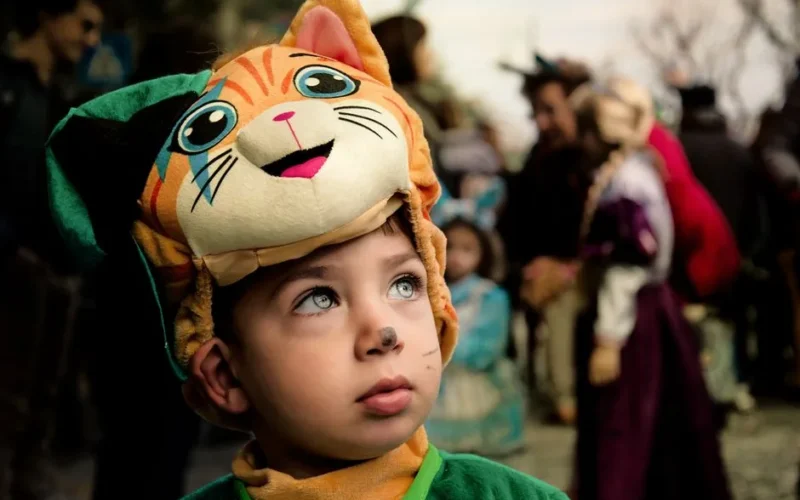Young boy in cat costume at Maiori Carnival, Italy, in a festive crowd.