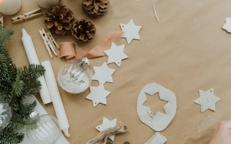 A flat lay of DIY Christmas decorations with pine cones and stars.