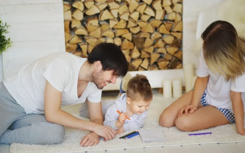 A joyful family drawing together on the living room floor, creating memories.