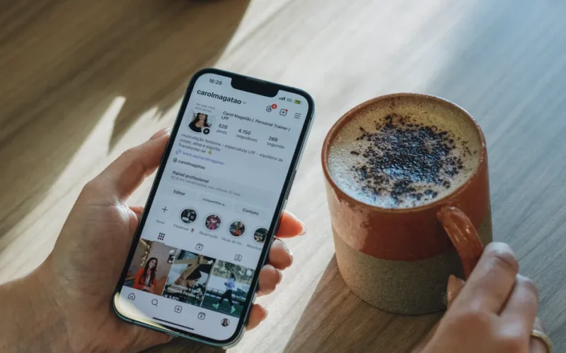Person browsing Instagram over coffee, relaxed morning vibe.
