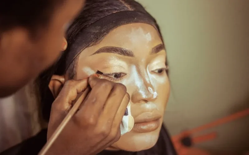 Close-up of makeup being professionally applied, highlighting skillful technique.