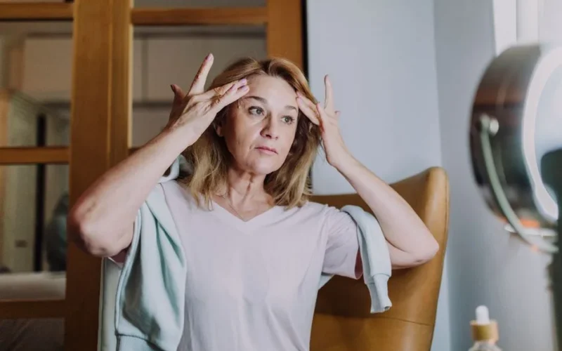 A mature woman practicing her skincare routine, emphasizing self-care and wellness.