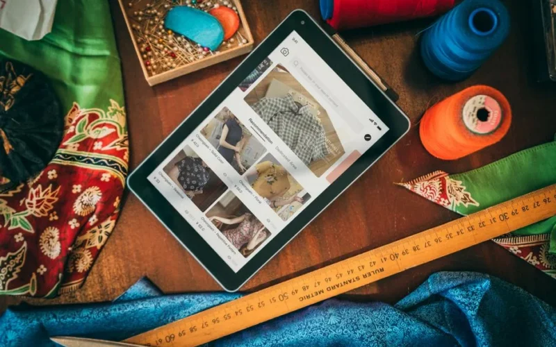 Flat lay of a tablet with sewing supplies, showcasing a digital platform for fabric and patterns.