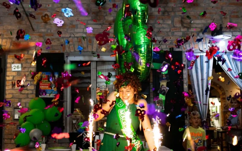 Festive birthday celebration with balloons, cake, and colorful confetti, highlighting a joyful atmosphere indoors.