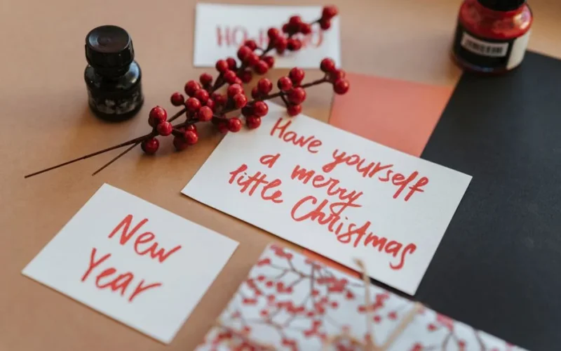Festive Christmas and New Year cards with holiday decorations and calligraphy.