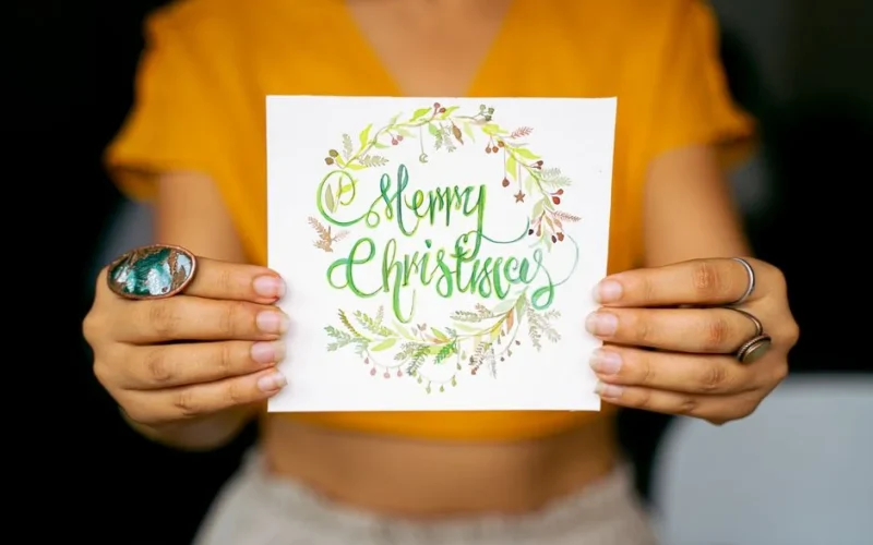Bright and festive Christmas card held by hands against a blurred background.