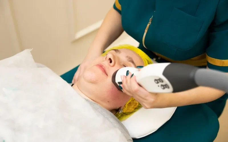 Close-up of a woman receiving a modern facial treatment in a beauty clinic.