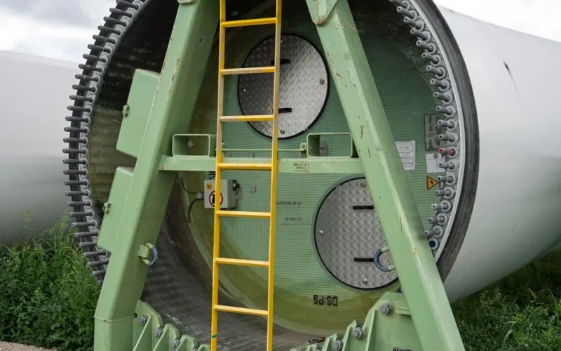 Close-up of a wind turbine section with a ladder attached, showcasing industrial design.