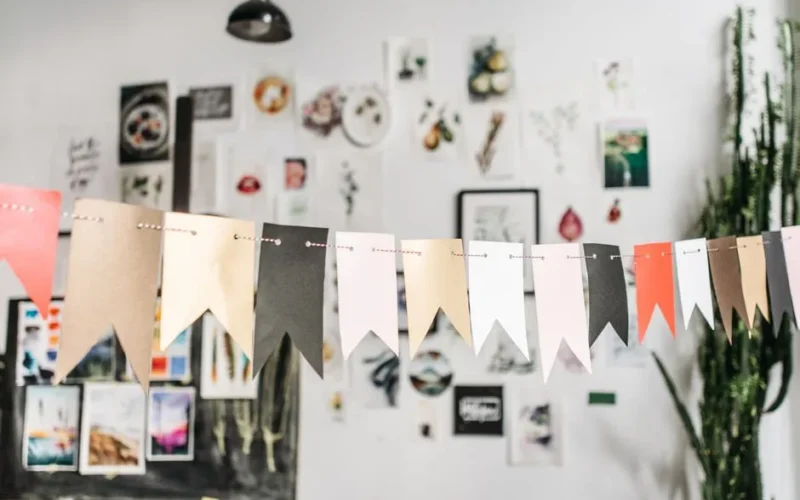 Artistic studio interior with decorative flag garlands and creative artworks on display.