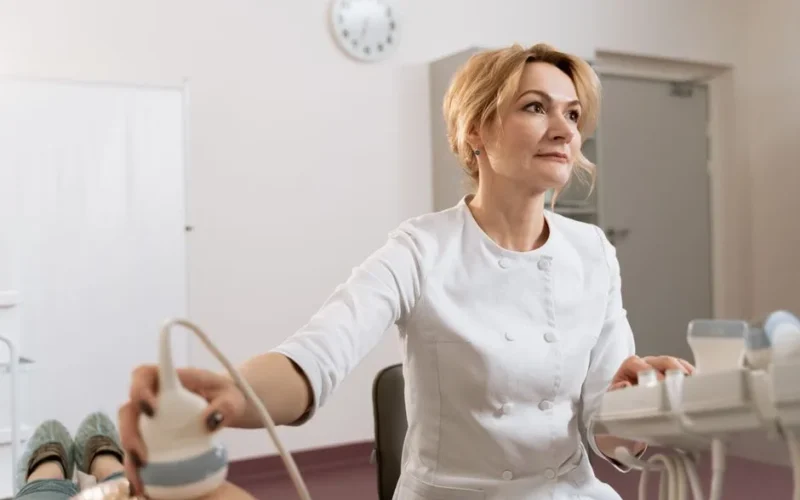 A female doctor performing an ultrasound in a medical clinic.