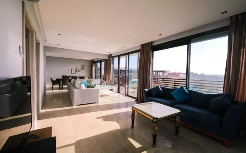 Bright and airy contemporary living room with furniture and large windows overlooking a city view.