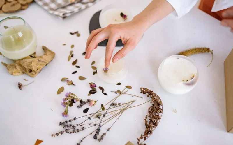 Creating handmade candles with dried flowers and leaves for unique decorations.