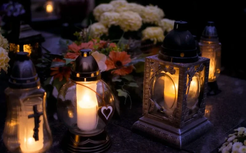 Lanterns with candles illuminate a cemetery on All Saints' Day.