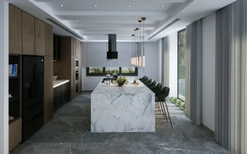 Spacious modern kitchen featuring a marble island, pendant lights, and natural light.