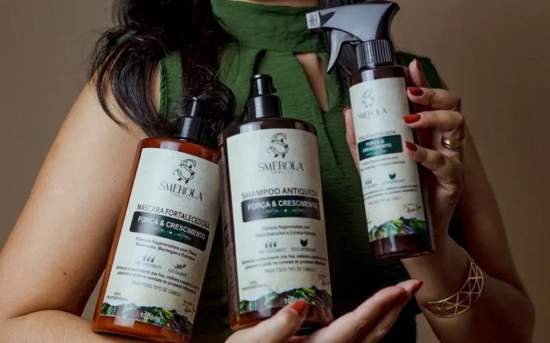 Close-up of a woman holding hair care products aimed at strengthening and stimulating hair growth.