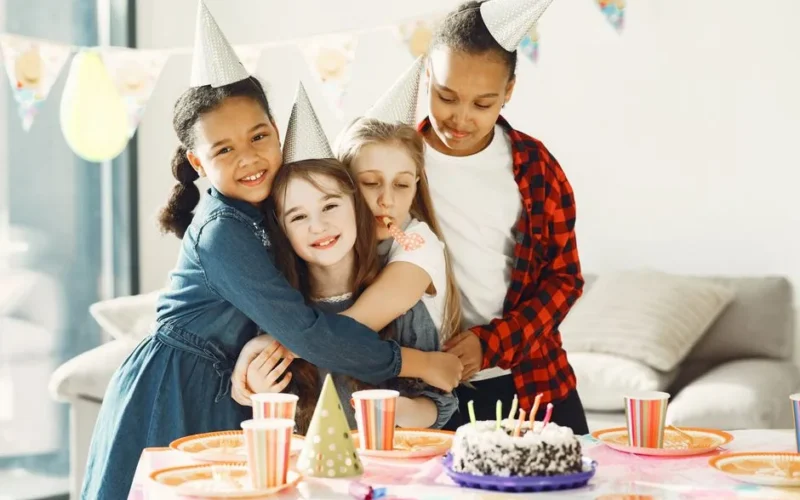 Group of kids enjoying a fun birthday party with cake and hats indoors.